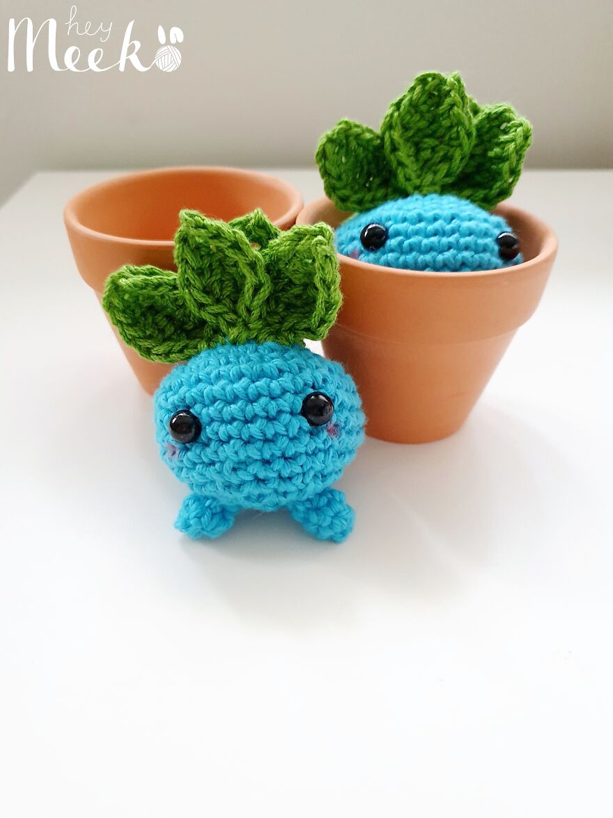 Crochet Oddish-inspired toys in terracotta pots on a white background, showcasing creative side hustle crafts.