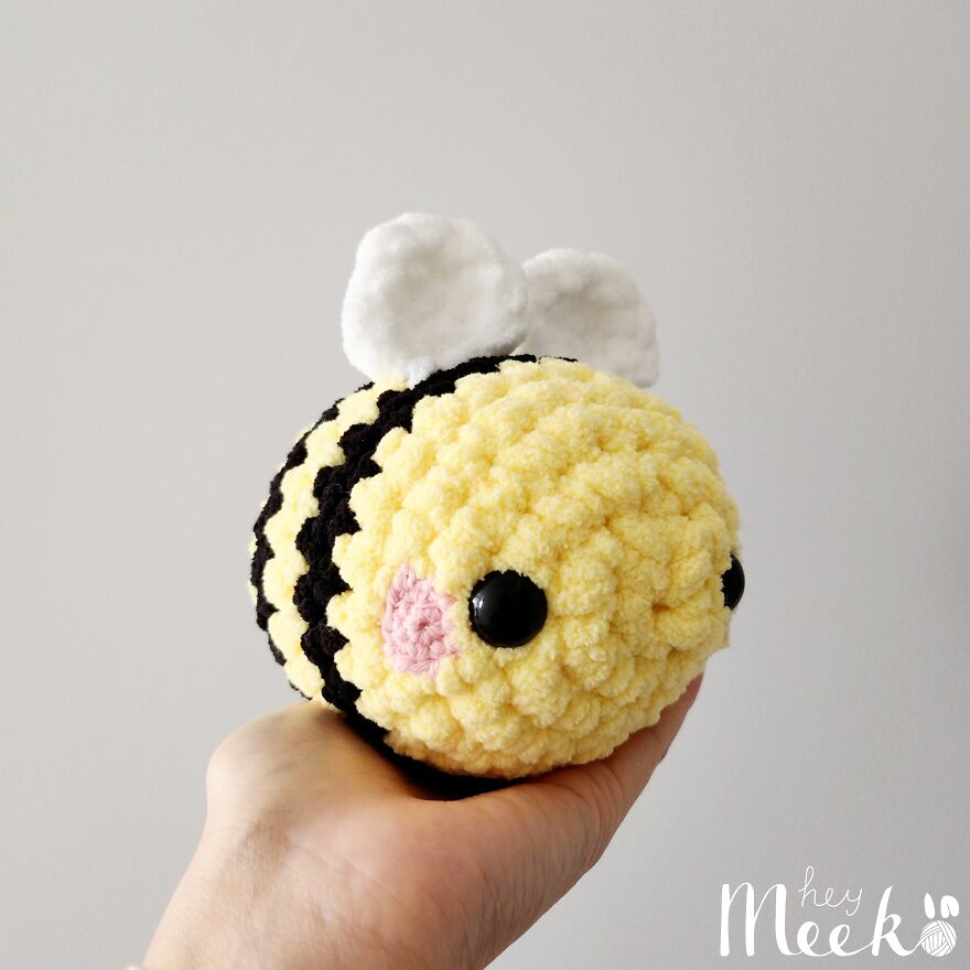 Crocheted bee amigurumi held in hand, showcasing a side hustle to make cute crocheted items.