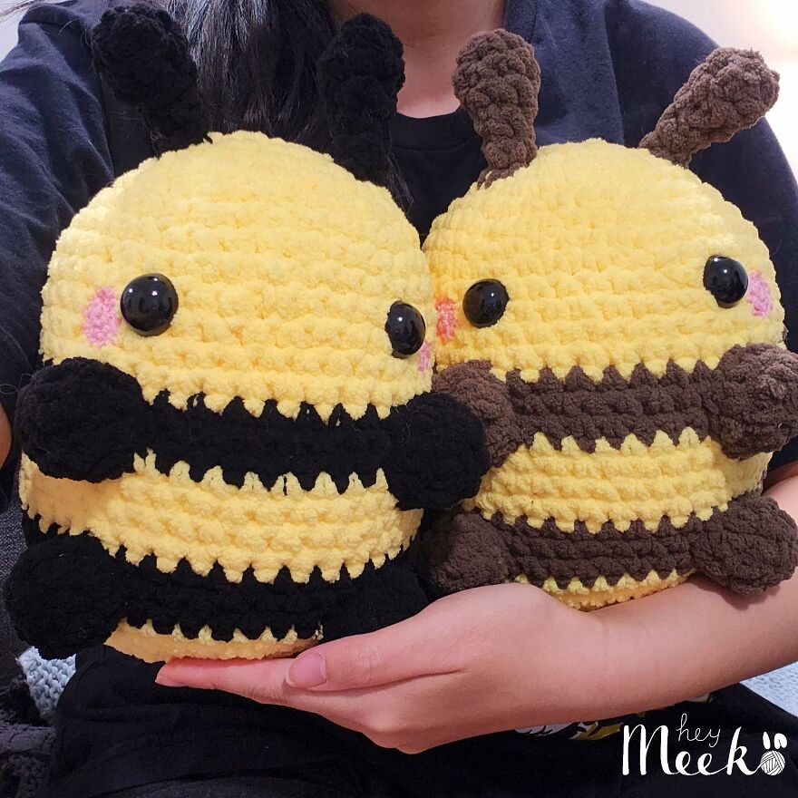 Crocheted bee plushies held by a person, showcasing a cute and cozy side hustle creation.