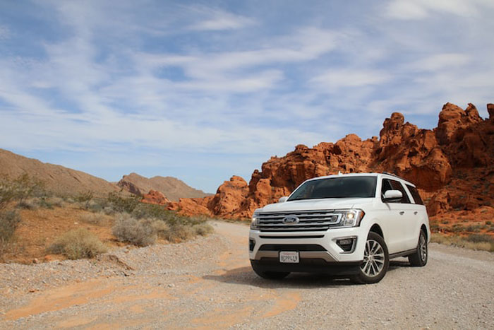 White SUV parked on a desert road with red rock formations, illustrating expensive mistakes seen by others.