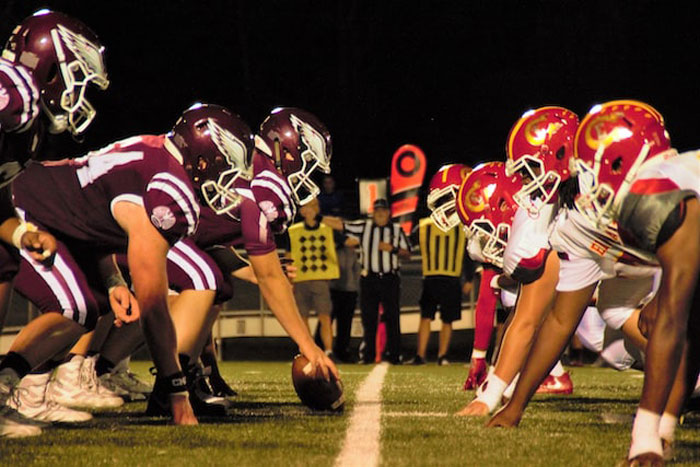 Two American football teams lined up at the line of scrimmage illustrating costly sports mistakes.