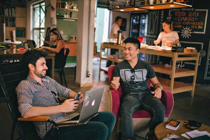 Two Guys Talking And Laughing At A Café