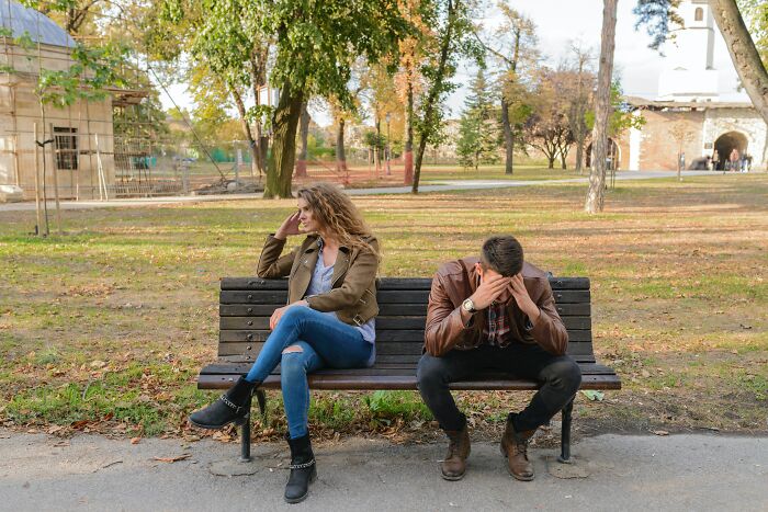Couple Arguing On The Bench In A Park 