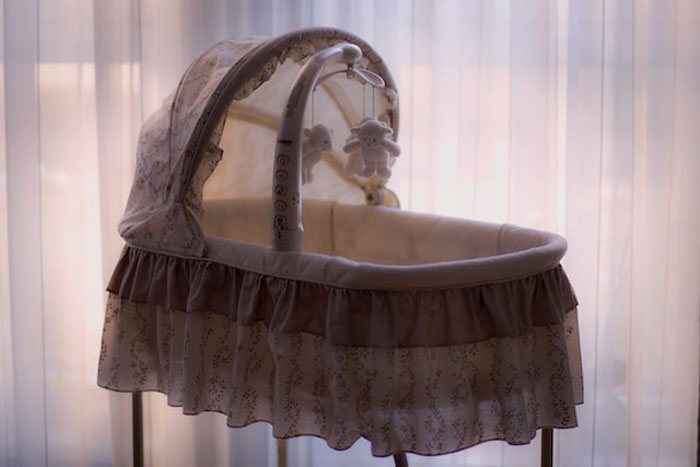 Empty vintage bassinet with soft lighting, evoking eerie vibes linked to creepy children's imaginary friends stories.