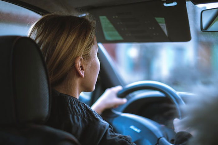 Woman with blonde hair driving a car, looking focused, illustrating a scene related to creepy stories about children's imaginary friends.