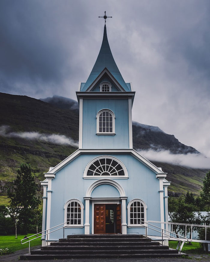 Blue church under gloomy sky, fitting the eerie mood of creepy stories about children's imaginary friends.