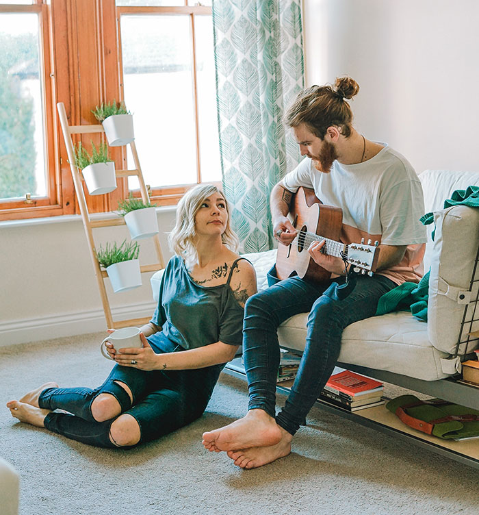 Picture of man playing guitar and woman looking