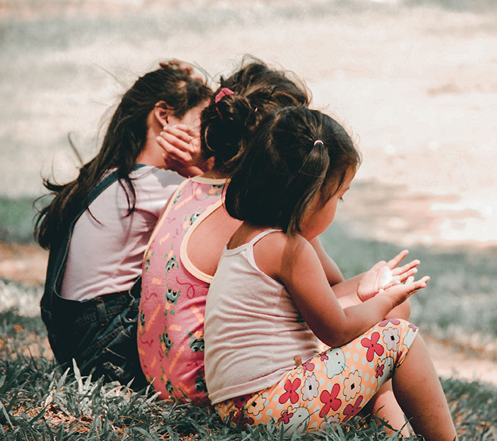 Childrens sitting near ocean