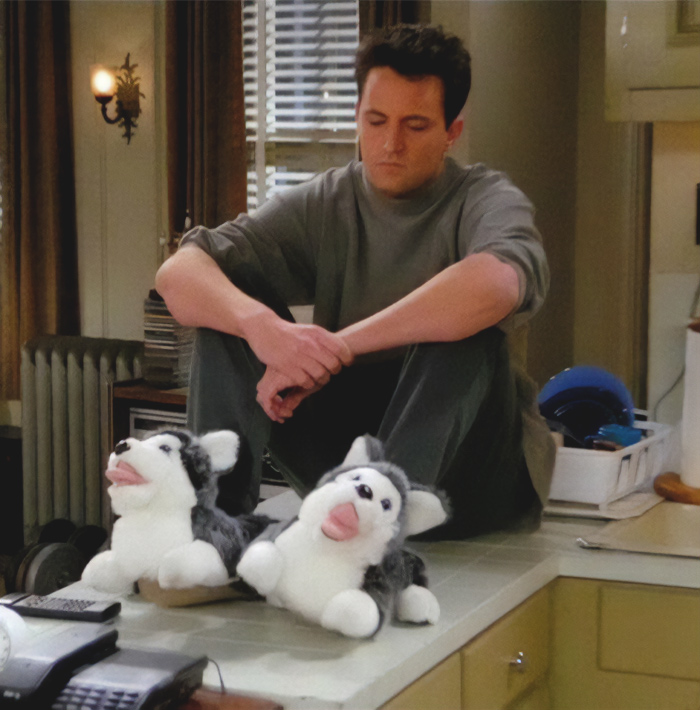 Man sitting on a kitchen counter wearing dog slippers, looking thoughtful and illustrating signs of a toxic relationship.