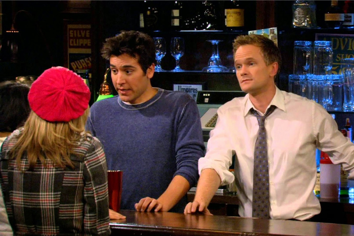Three people talking at a bar, illustrating signs of a fake friend in a toxic relationship scenario.