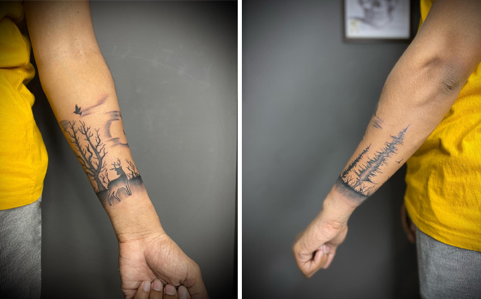 Person showcasing nature-themed armband tattoos with trees and wildlife on their forearms.
