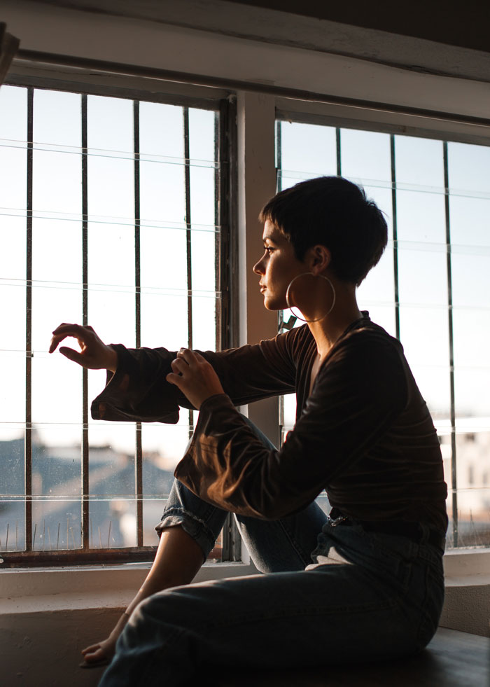 Woman sitting and watching through the window 