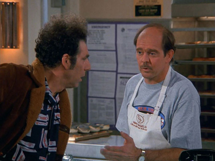Kramer and a man wearing apron talking 