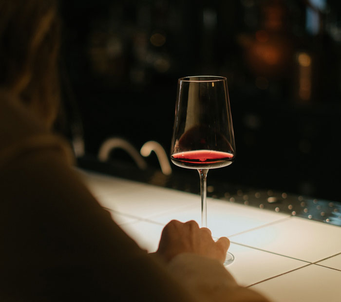 Woman holding clear wine glass