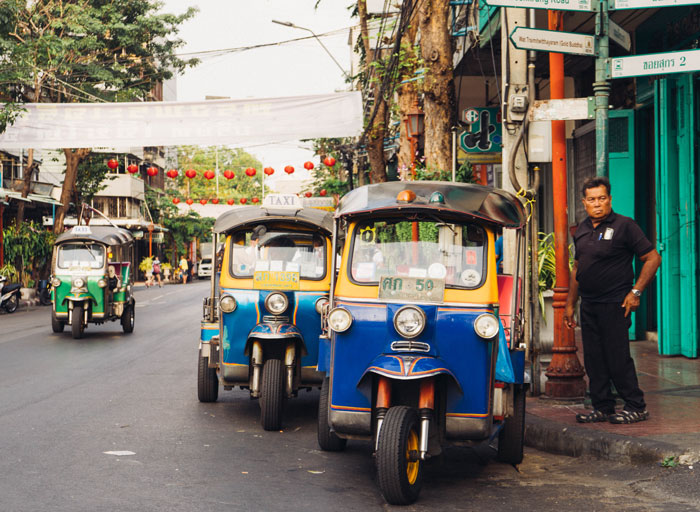 Man standing beside parked trikes