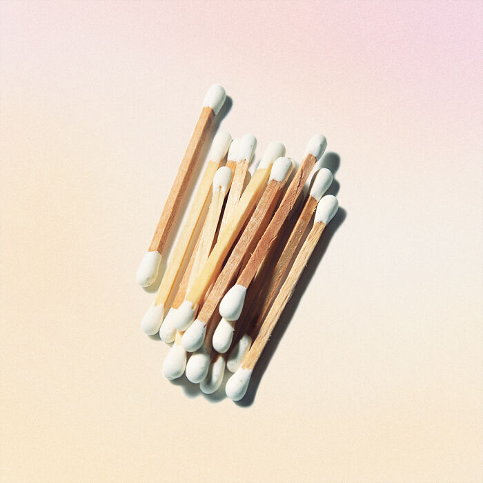 Creative conceptual product design featuring a cluster of wooden cotton swabs on a soft gradient background.