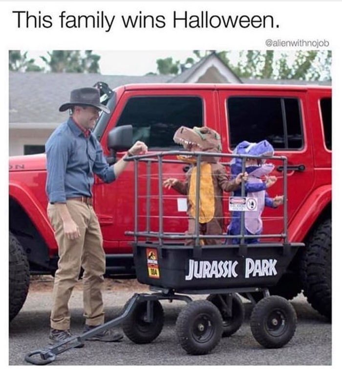 Man with cowboy hat beside kids in dinosaur costumes in a Jurassic Park wagon, representing wholesome memes.