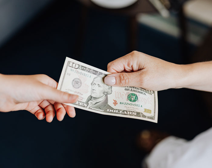 Two person holding a dollar