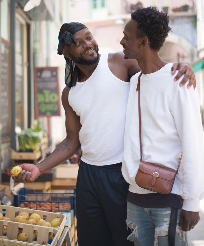 Two men are talking at the store while hugging each other