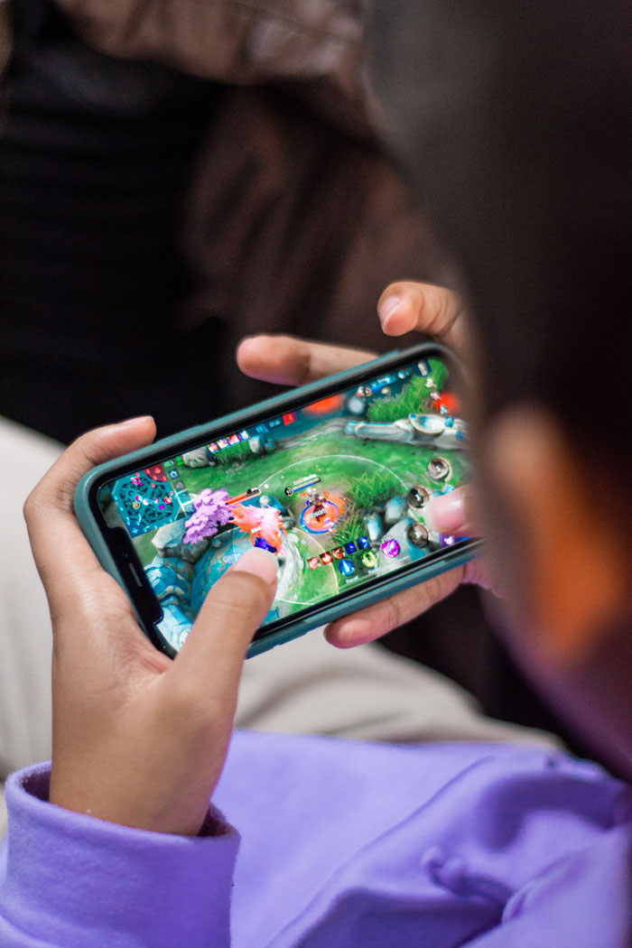 A kid playing game on the phone 