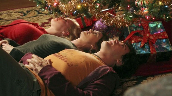 Meredith, Izzie and George lying under the Christmas tree 