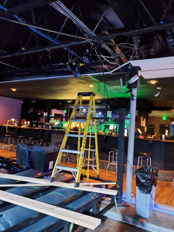 Unsafe setup with ladder and planks in a bar, disregarding OSHA safety regulations.