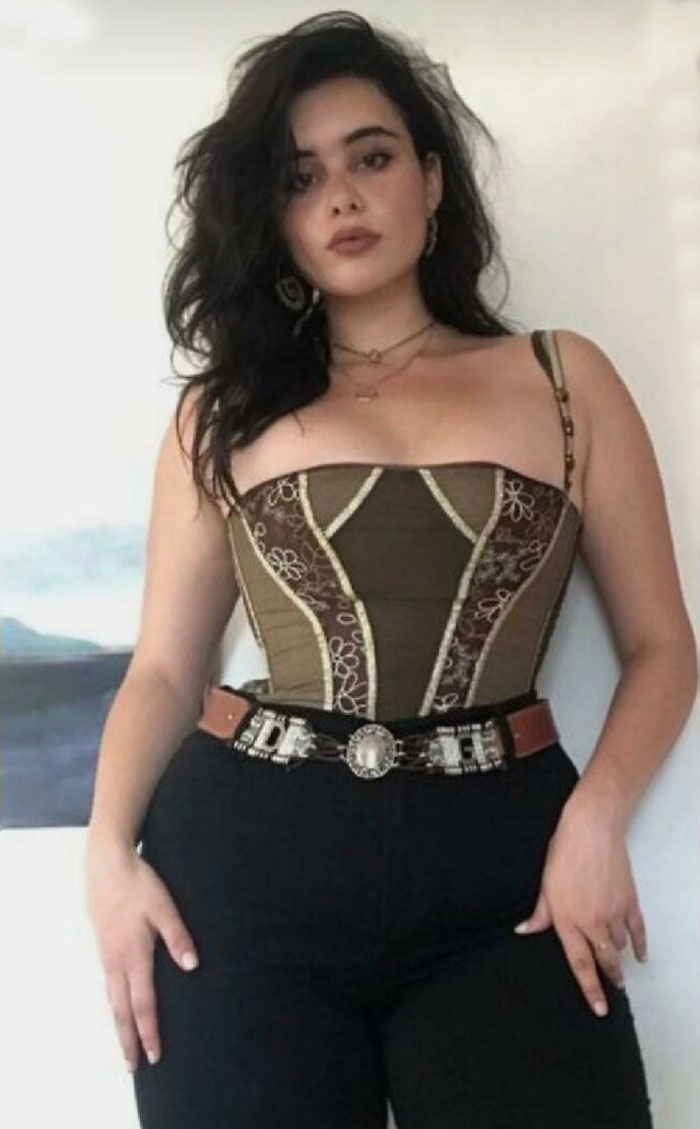 Woman posing confidently in a corset top and belt, illustrating Instagram reality with a styled online photo look.