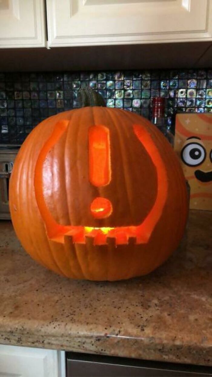 Pumpkin carved with a surprised emoji face glowing on a kitchen counter, capturing kids making parents laugh Halloween moment.