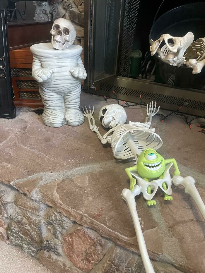Halloween decorations with skeleton toys and a green monster figure, capturing kids making parents laugh during Halloween.