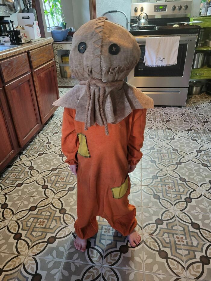 Child wearing a spooky Halloween costume in a kitchen, showcasing kids making parents laugh during Halloween.