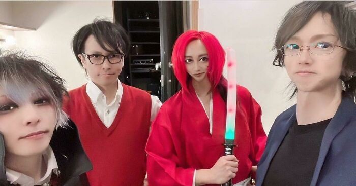 Four people posing for a selfie indoors, one with bright red hair holding a glowing sword, illustrating Instagram reality fake pics.