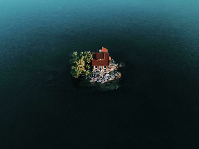A small isolated house surrounded by ocean water, creating a frightening and eerie atmosphere near the ocean.