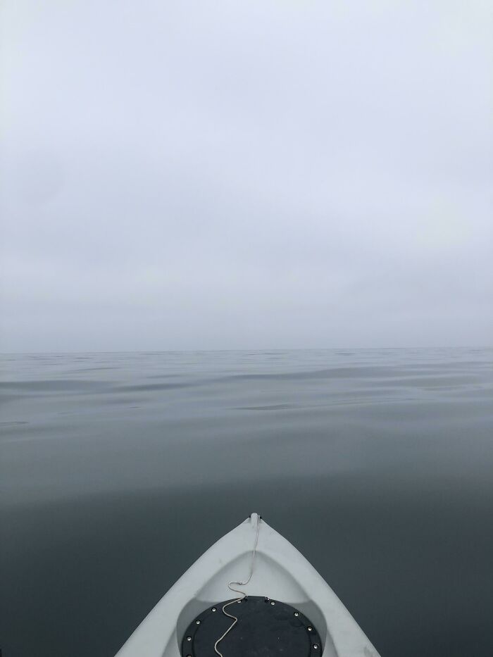 Front view from a boat over calm, foggy ocean waters, evoking frightening ocean scenes and isolation.