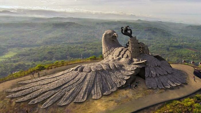 Massive stone eagle sculpture with detailed wings set on a hillside, showcasing impressive architectural design and creativity.