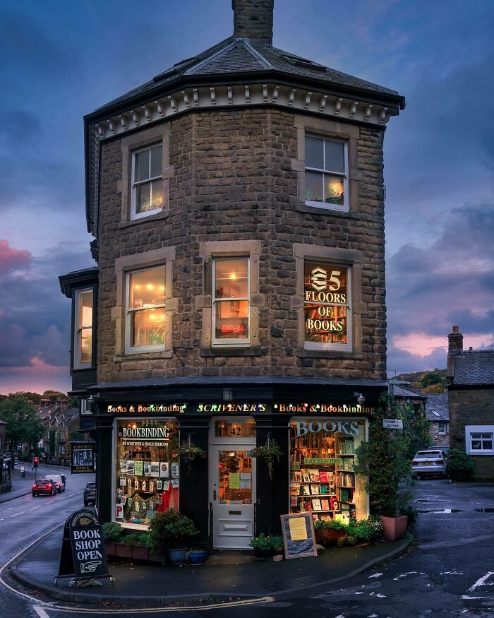 Stone building with unique architecture housing a bookshop at dusk, showcasing creative architectural design by architects.