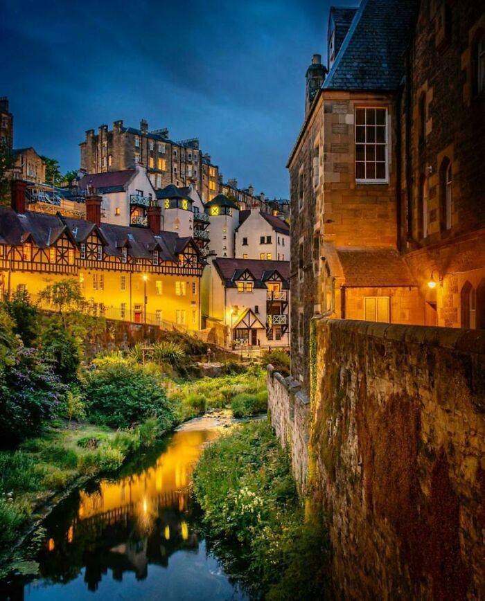 Evening view of charming historic buildings by a river showcasing architects' impressive and praised architectural design skills.