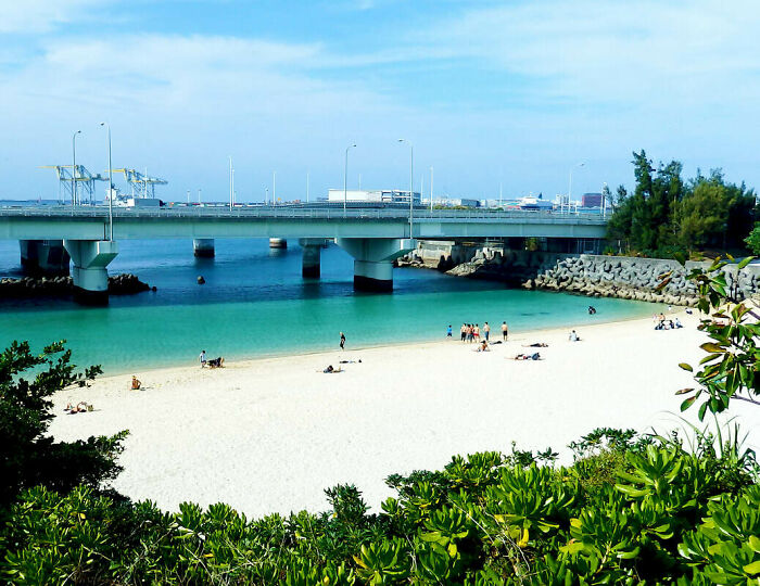 A Highway Bridge Across A Beach In Naha, Japan