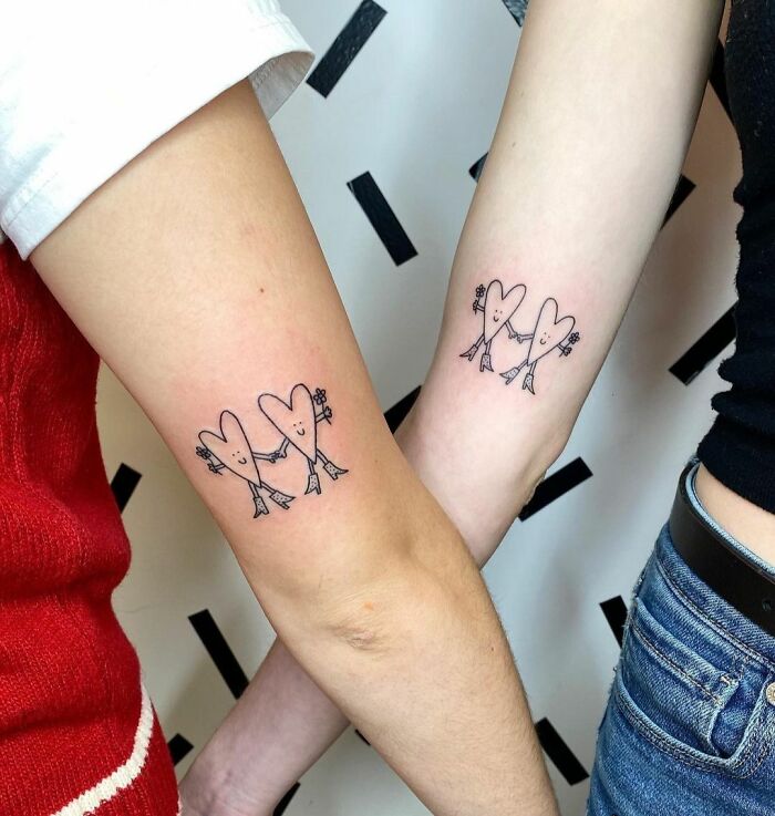 Friend tattoos of two cute hearts holding hands, symbolizing strong friendship.