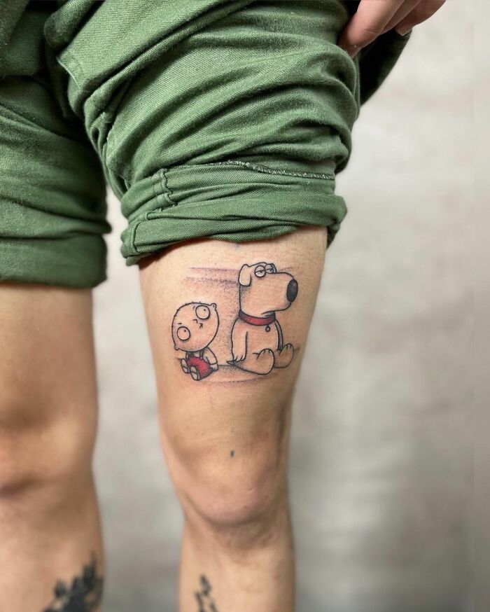 Cartoon tattoo of Stewie and Brian on a leg, showcasing nostalgic ink art.