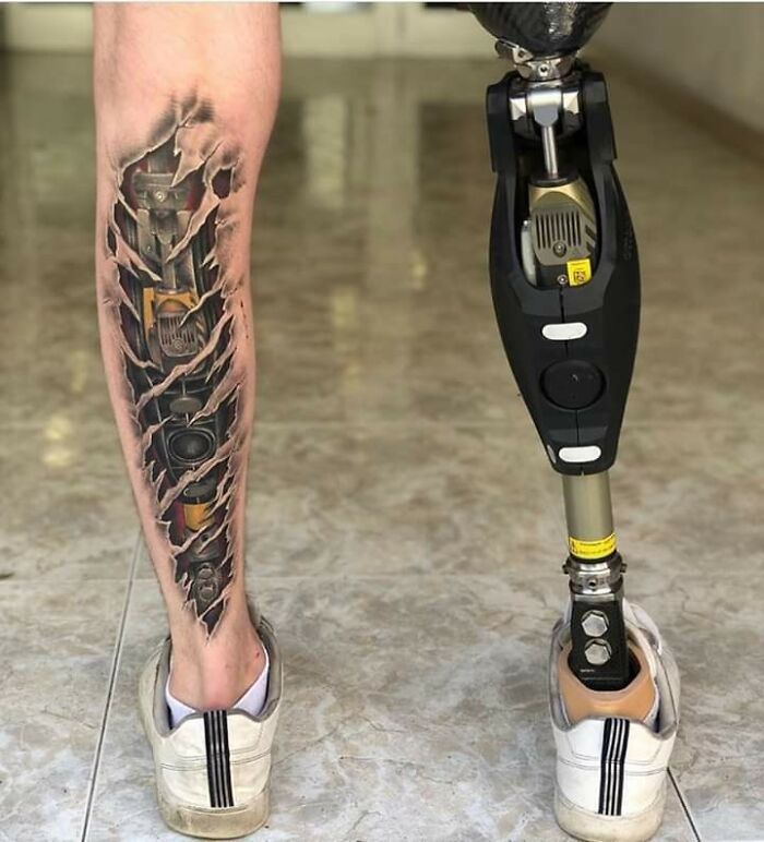 Creative tattoo design on a leg, next to a prosthetic limb, showcasing imaginative art.
