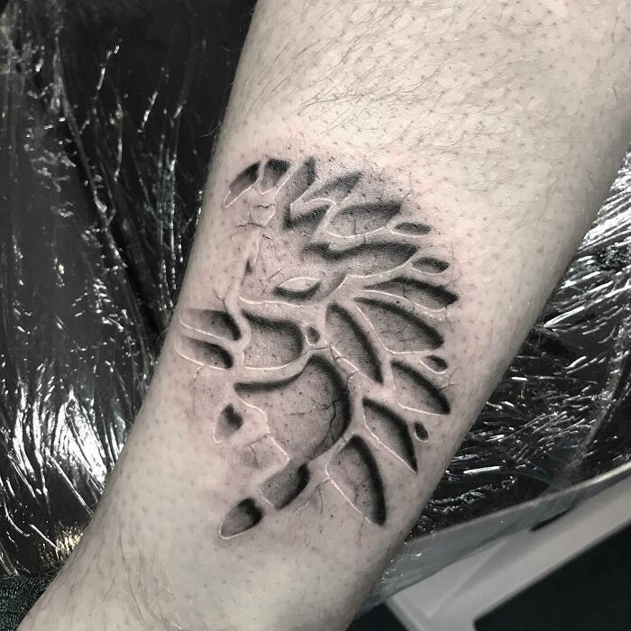 Creative tattoo design resembling a carved-out silhouette on arm, shared in an online group.