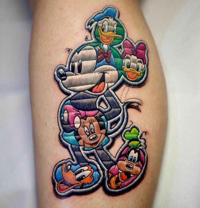 Creative tattoo design featuring cartoon characters, resembling a patchwork embroidery.