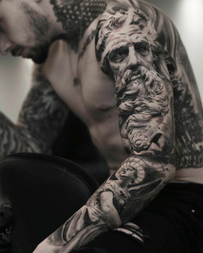 Intricate tattoo designs covering a man's arm, showcasing detailed artwork and shading.