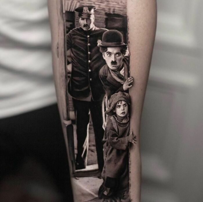 Detailed tattoo design of classic film characters on a person's leg.