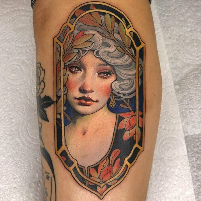 Stunning tattoo design of a woman's portrait with floral elements on an arm.