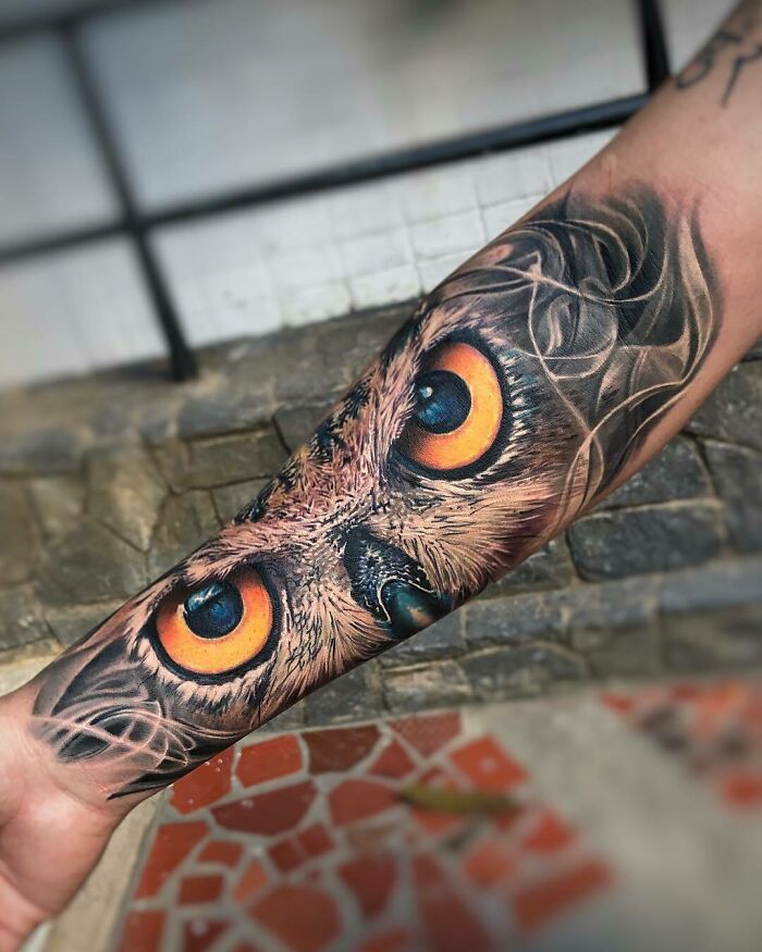 Detailed owl tattoo on an arm showcasing realistic design and vibrant colors.