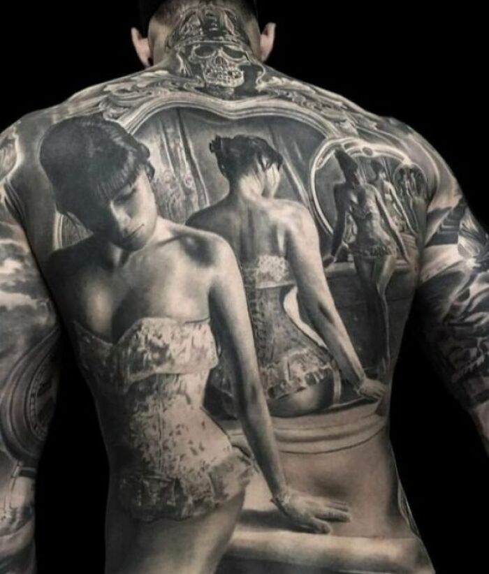 Detailed tattoo design featuring a woman in a mirror on a person's back.