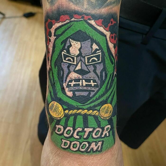Colorful Marvel tattoo of Doctor Doom on forearm, showcasing vibrant superhero art.