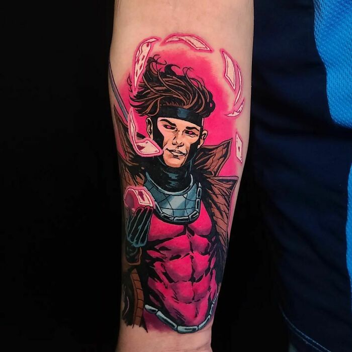 Marvel tattoo of a superhero Gambit on forearm, showcasing vibrant colors and intricate design.