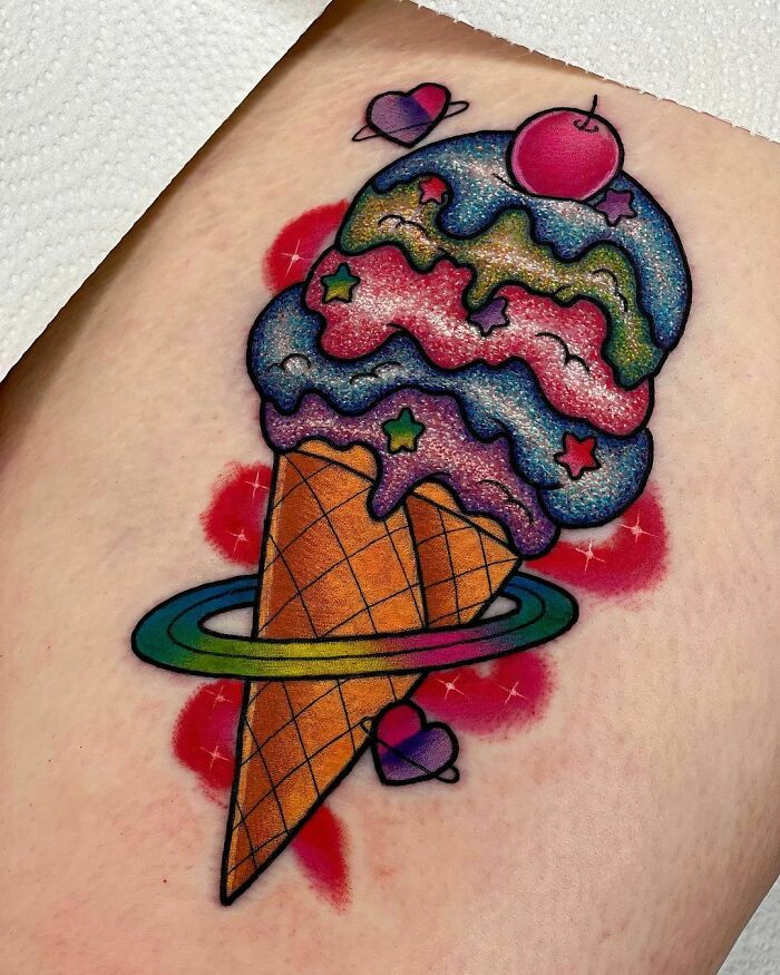 Colorful glitter tattoo of an ice cream cone with planets and stars.